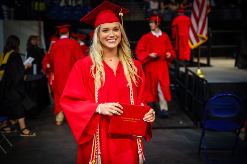Students in red robes graduate